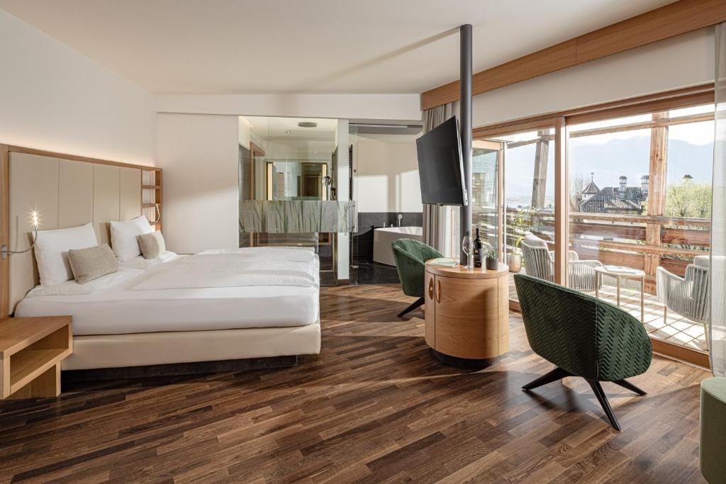 une chambre d'hôtel avec un lit et un balcon dans l'établissement Lake Spa Hotel SEELEITEN, à Caldaro