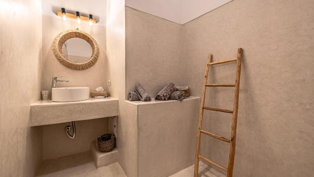 La salle de bains est pourvue d'un lavabo, d'un miroir et d'une échelle. dans l'établissement Riad Dar Asam, à Marrakech