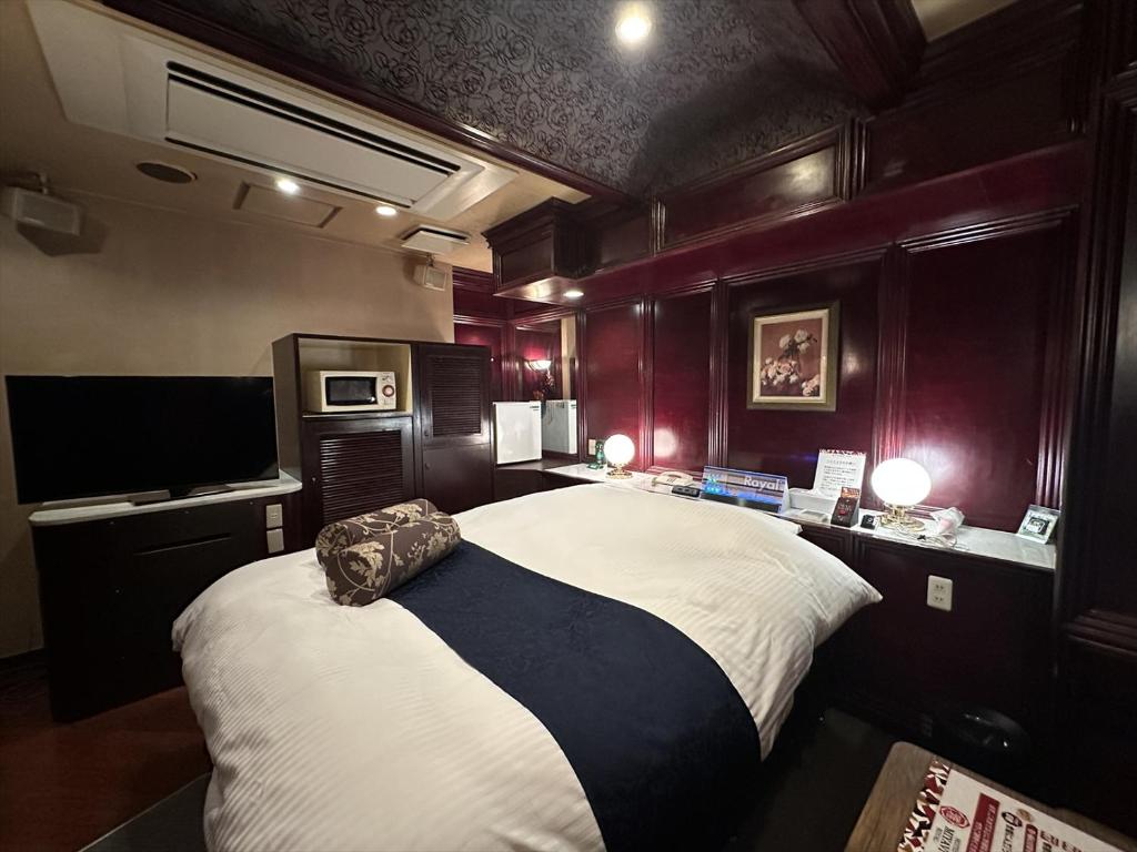 une chambre avec un grand lit et une télévision dans l'établissement ホテル雅ロワイヤル, à Shimo-shirōzu