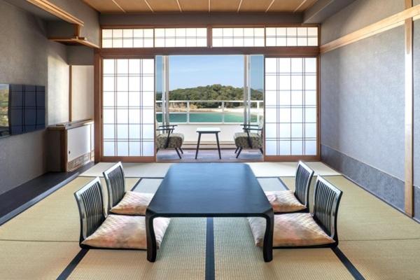 Cette chambre avec vue comprend une table et des chaises. dans l'établissement Hotel Sanrakuso, à Shirahama