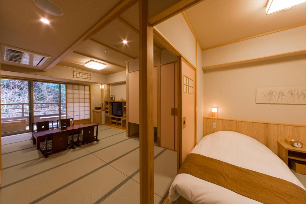 une chambre avec un lit, un bureau et une fenêtre dans l'établissement Ikyu, à Ise
