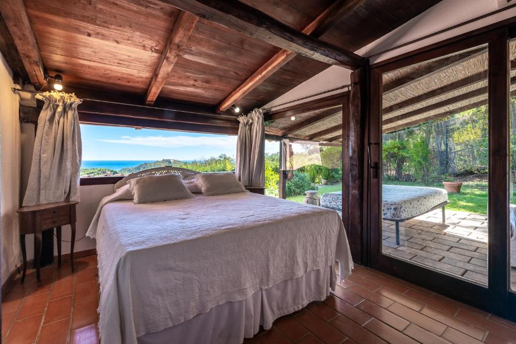 une chambre avec un lit et une grande fenêtre dans l'établissement Porto Ercole Prestige Villa, à Cala Galera
