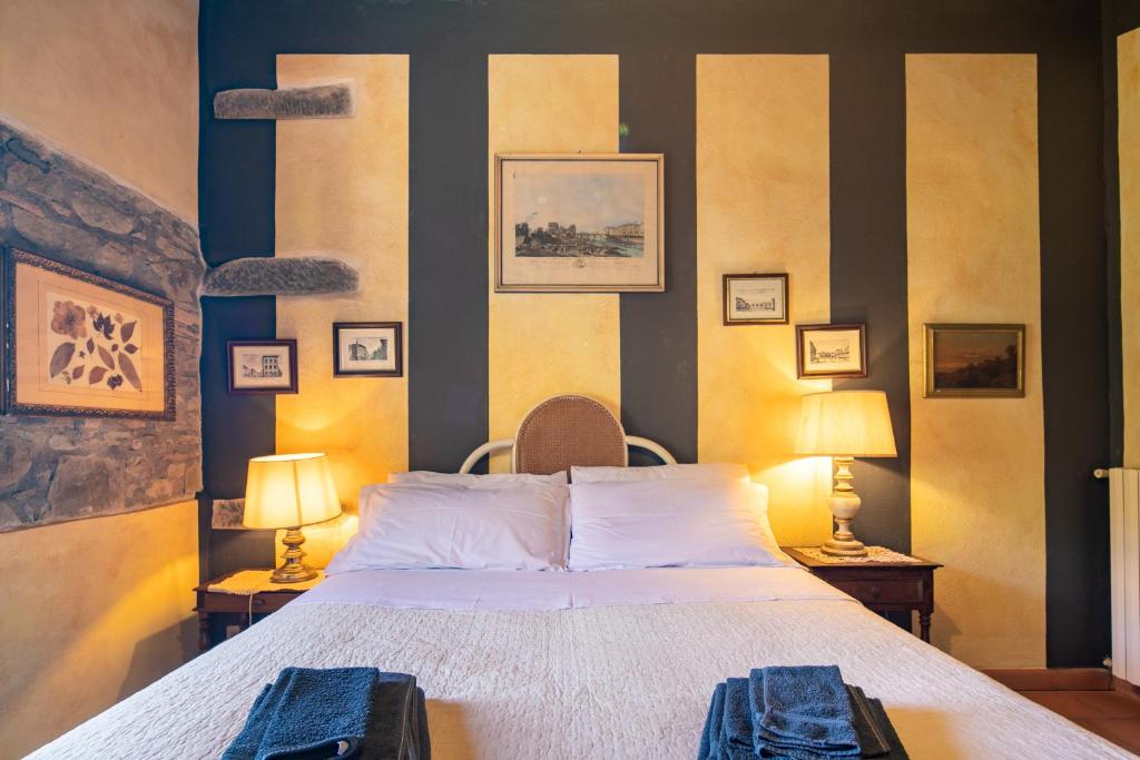une chambre avec un grand lit et deux lampes dans l'établissement Casale Giaggiolo, à Incisa in Valdarno