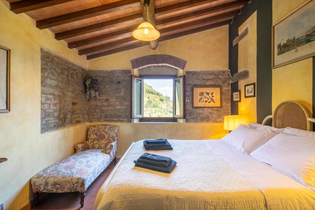 une chambre avec un lit, une chaise et une fenêtre dans l'établissement Casale Giaggiolo, à Incisa in Valdarno