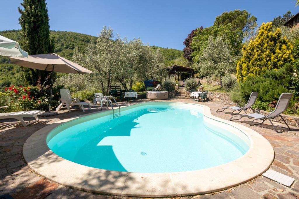 une piscine avec des chaises et un parasol dans l'établissement Casale Giaggiolo, à Incisa in Valdarno