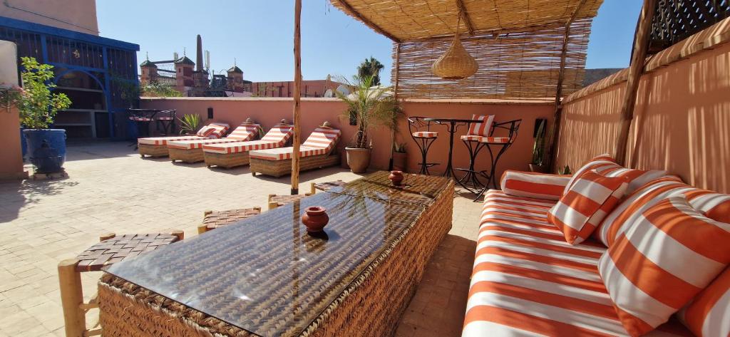 - une terrasse avec un bouquet de chaises et une table dans l'établissement Riad Babmoon - Private Riad with Pool & Rooftop, à Marrakech