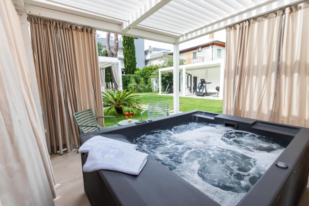un bain à remous installé dans un patio avec dans l'établissement Hotel Al Cigno, à Lignano Sabbiadoro