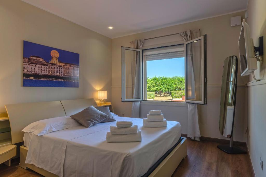 une chambre avec un grand lit avec des serviettes dessus dans l'établissement Villa Sambucia - Sicilian Charm, Entirely Private, à Syracuse