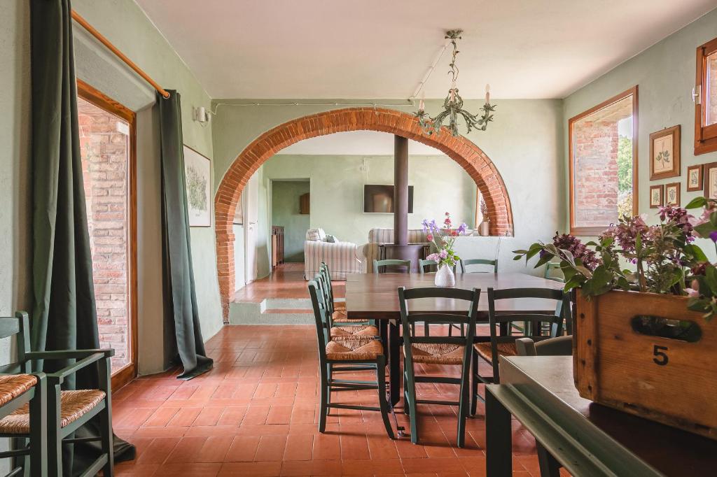 une salle à manger avec une voûte, une table et des chaises dans l'établissement Podere Mencoini, stylish villa with private pool and olive garden, à Scrofiano