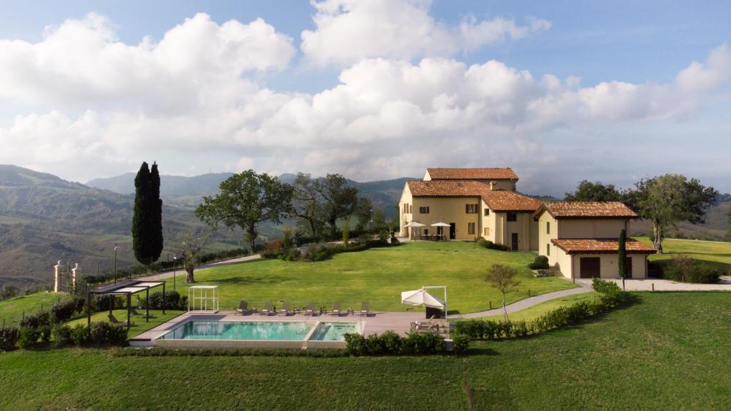 une maison sur une colline avec une piscine dans l'établissement SANTA MARIA MADDALENA 10, Emma Villas, à Castel San Pietro Terme