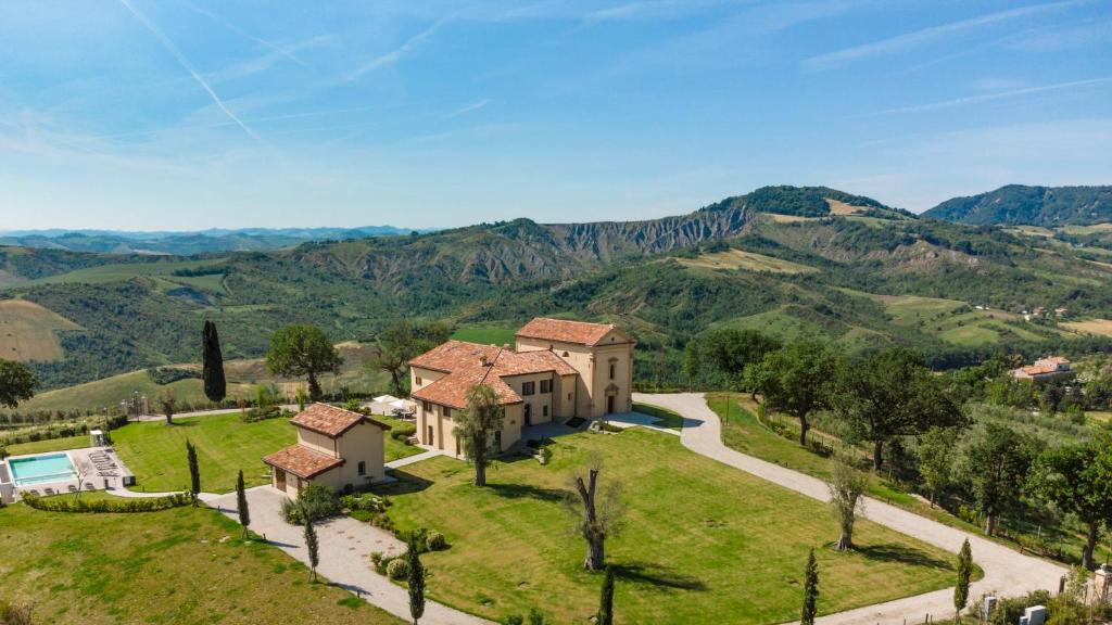 un domaine dans les collines avec des montagnes en arrière-plan dans l'établissement SANTA MARIA MADDALENA 10, Emma Villas, à Castel San Pietro Terme