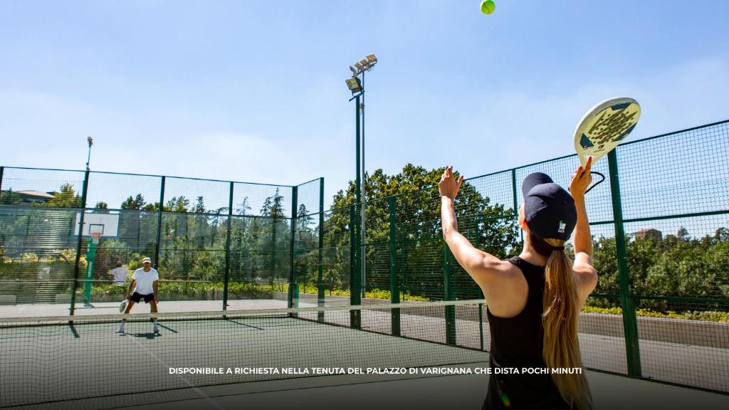 une femme tenant une raquette de tennis sur un court de tennis dans l'établissement SANTA MARIA MADDALENA 10, Emma Villas, à Castel San Pietro Terme