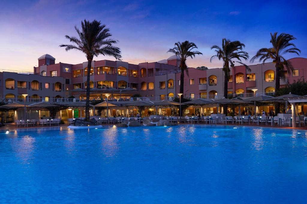 une grande piscine devant un hôtel dans l'établissement Almar Timi Ama Villasimius, à Villasimius