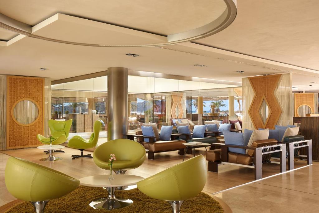 - une salle d'attente avec des chaises vertes et bleues dans l'établissement Almar Timi Ama Villasimius, à Villasimius