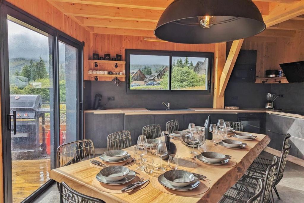 une salle à manger avec une table et des chaises en bois dans l'établissement La Flèche 1 - Chalet Standing - Jacuzzi Privatif, à Besse-et-Saint-Anastaise
