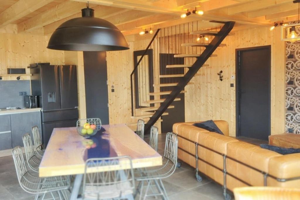 une salle à manger avec une table et un canapé dans l'établissement La Flèche 2 - Chalet Standing - Jacuzzi Privatif, à Besse-et-Saint-Anastaise 37 autres photos
