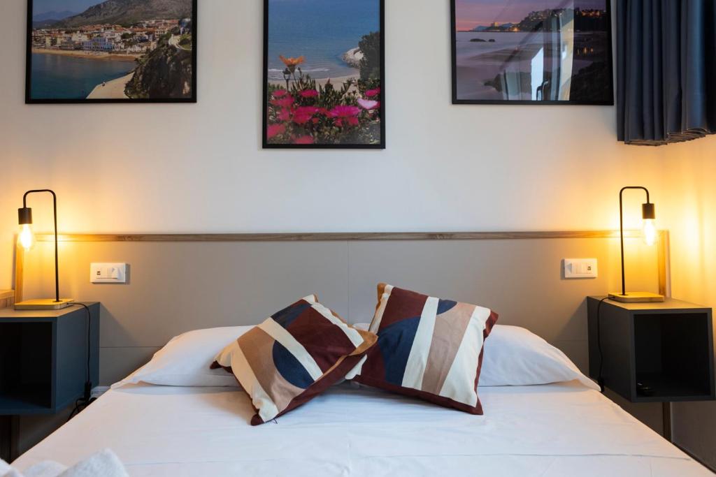 une chambre avec un lit avec trois tableaux au mur dans l'établissement Sperlonga Center Holiday B&B, à Sperlonga