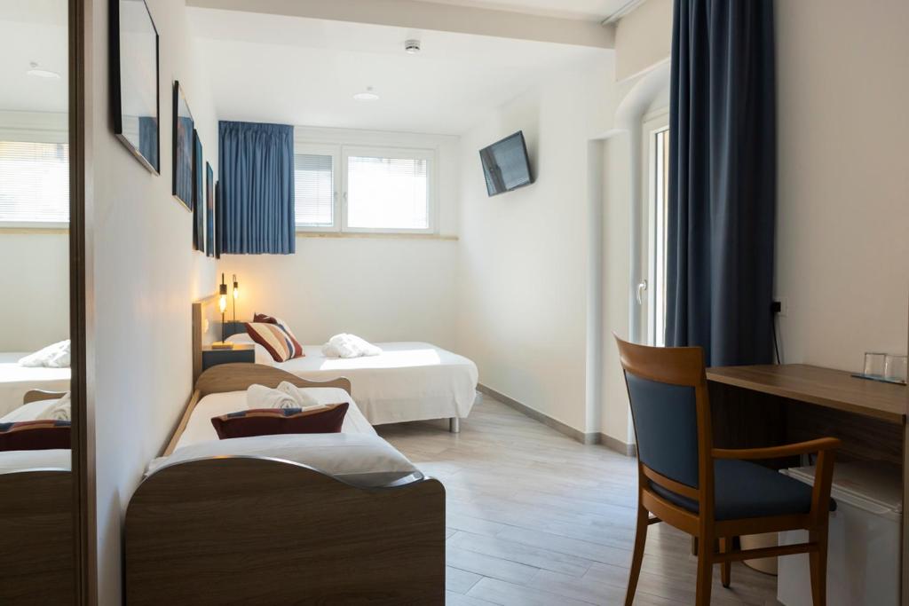 une chambre d'hôtel avec deux lits et un bureau dans l'établissement Sperlonga Center Holiday B&B, à Sperlonga