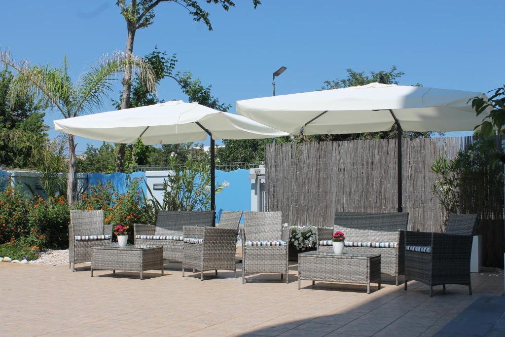 un groupe de chaises et de parasols sur une terrasse dans l'établissement Residence Blumarine, à Giulianova