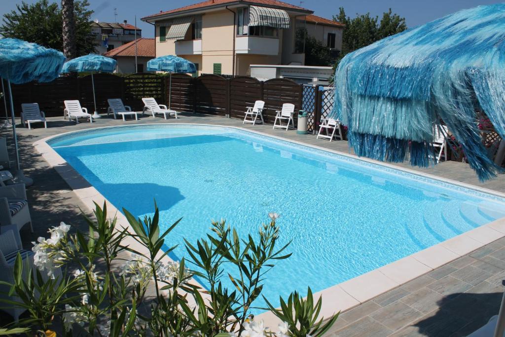 une grande piscine avec chaises et parasols dans l'établissement Residence Blumarine, à Giulianova