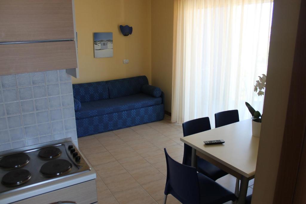 un salon avec une table et un canapé bleu dans l'établissement Residence Blumarine, à Giulianova