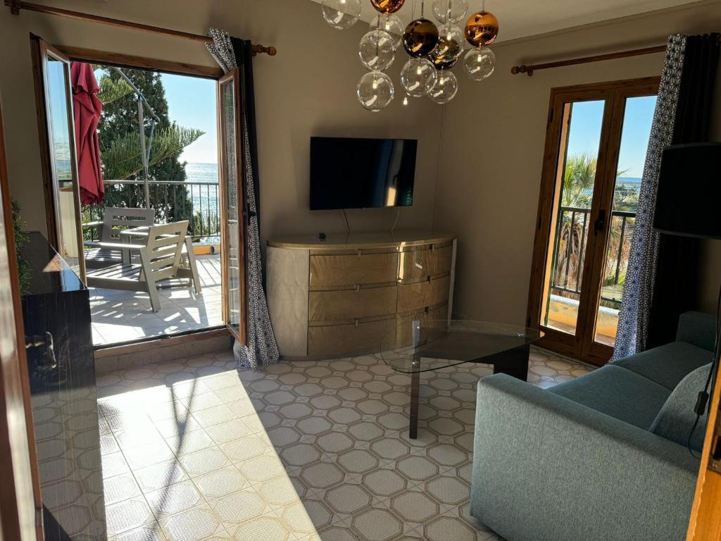 un salon avec une télévision, un canapé et une table dans l'établissement Hotel Lora RDA Luxury, à Bordighera