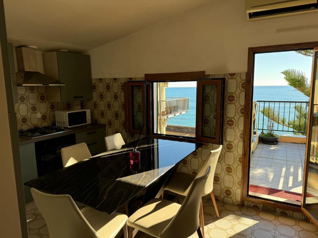 - une cuisine avec une table et des chaises offrant une vue sur l'océan dans l'établissement Hotel Lora RDA Luxury, à Bordighera