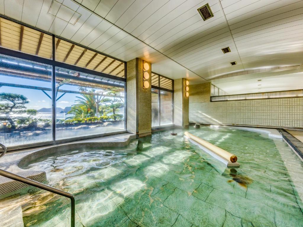 une grande piscine d'eau dans un bâtiment dans l'établissement Inatori Ginsuiso, à Higashiizu