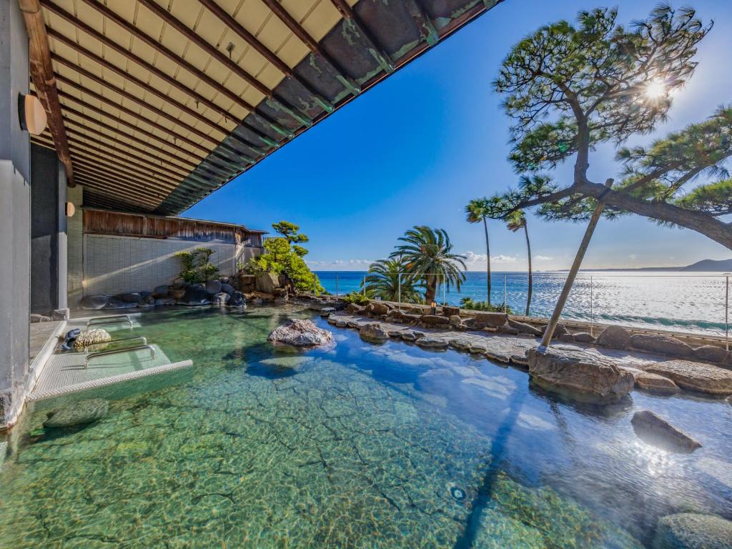 une piscine extérieure avec l'océan en arrière-plan dans l'établissement Inatori Ginsuiso, à Higashiizu
