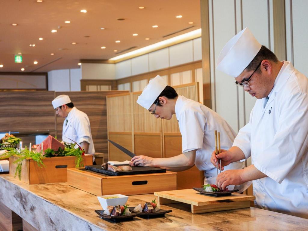 - un groupe de chefs préparant des plats dans une cuisine dans l'établissement Dogashima New Ginsui, à Nishiizu
