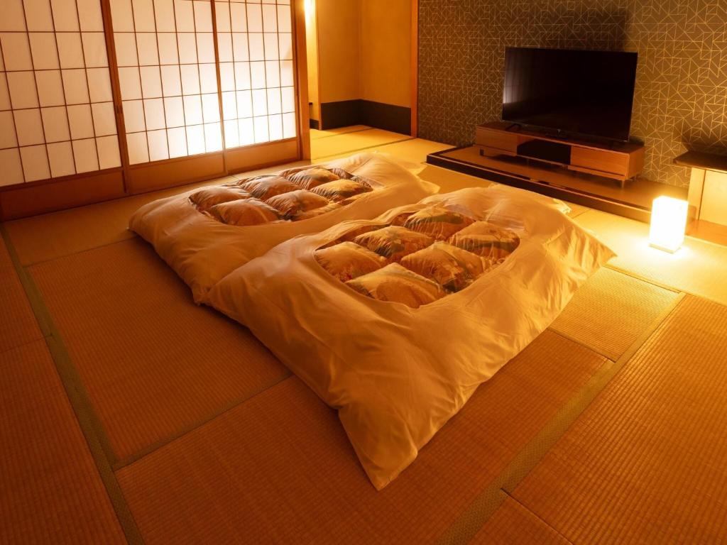 un groupe de pains sur un lit dans une pièce dans l'établissement Dogashima New Ginsui, à Nishiizu