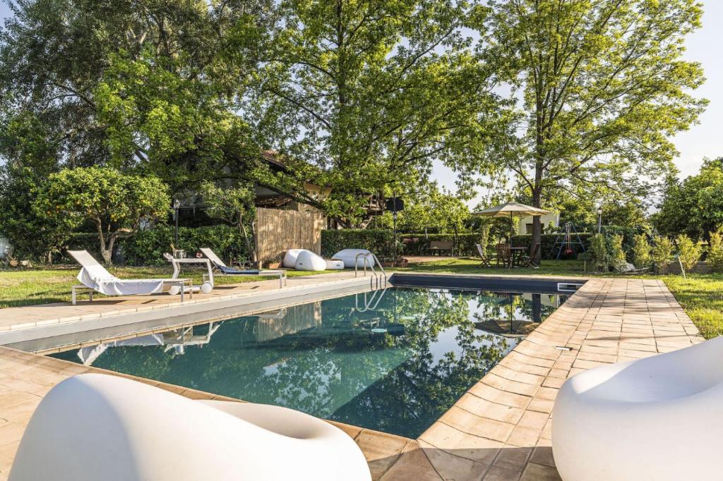 une piscine avec des chaises et une maison dans l'établissement Villa Tina, à Taormine