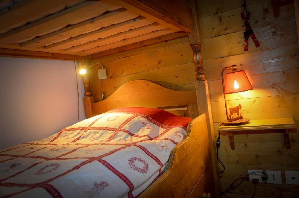 une chambre avec un lit dans une cabane en bois dans l'établissement T2 Meublé Tourisme 3 etoiles, pied des pistes-parking privé avec balcon et superbe vue, à Les Deux Alpes