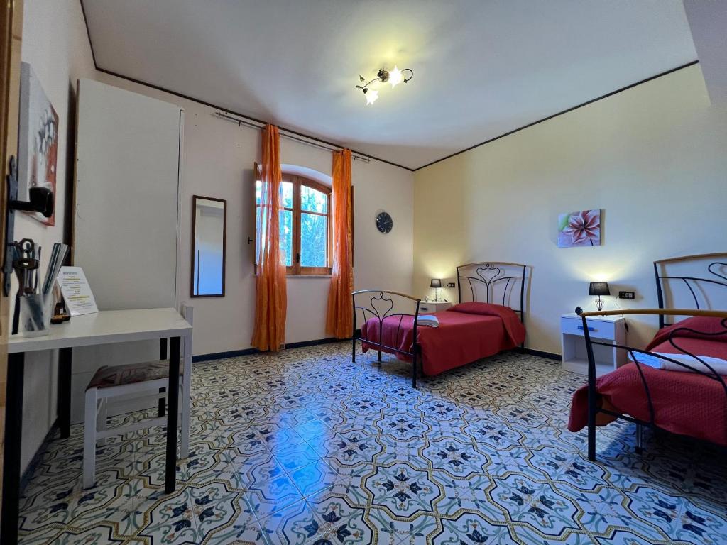 une chambre avec deux lits, une table et un bureau dans l'établissement Villa La Terrazza Sul Mare di Trabia, à Trabia