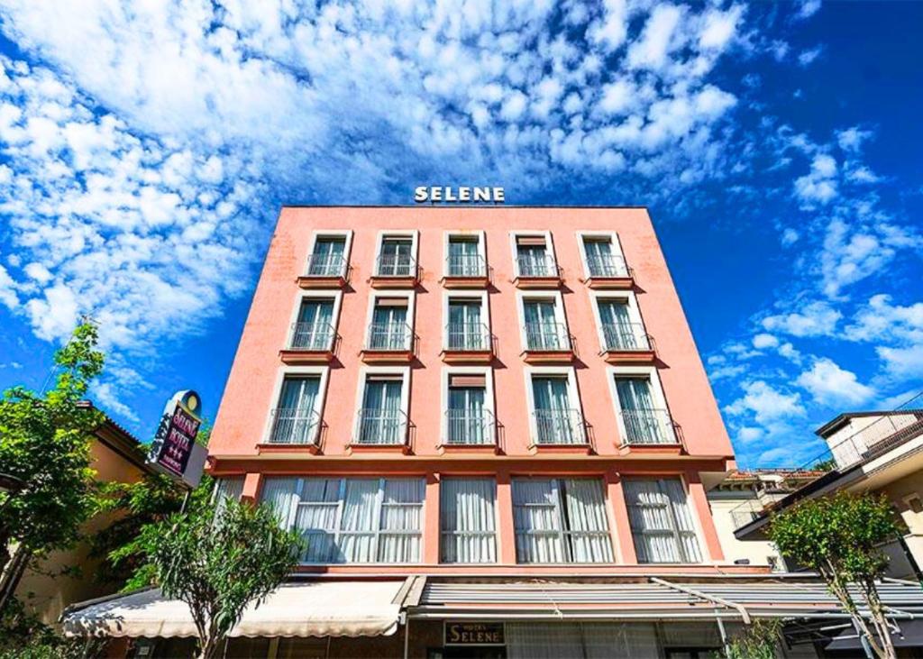 un grand bâtiment rouge portant le nom d'un hôtel dans l'établissement Hotel Selene - Vista Mare, à Riccione