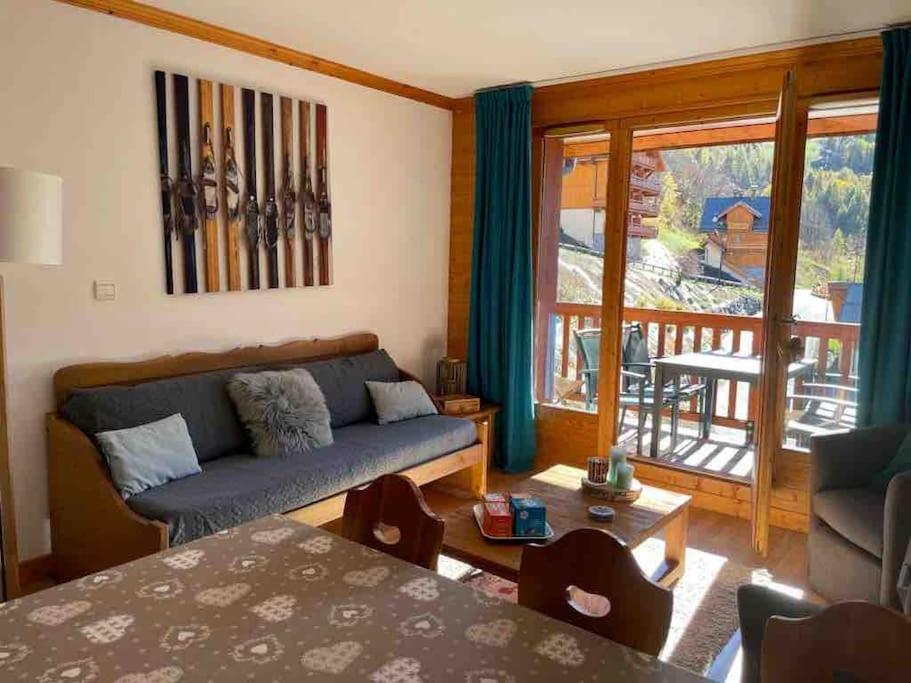 d'un salon avec un canapé et un balcon. dans l'établissement Duplex T3, ski aux pieds, plein sud, Piscine, à Valloire