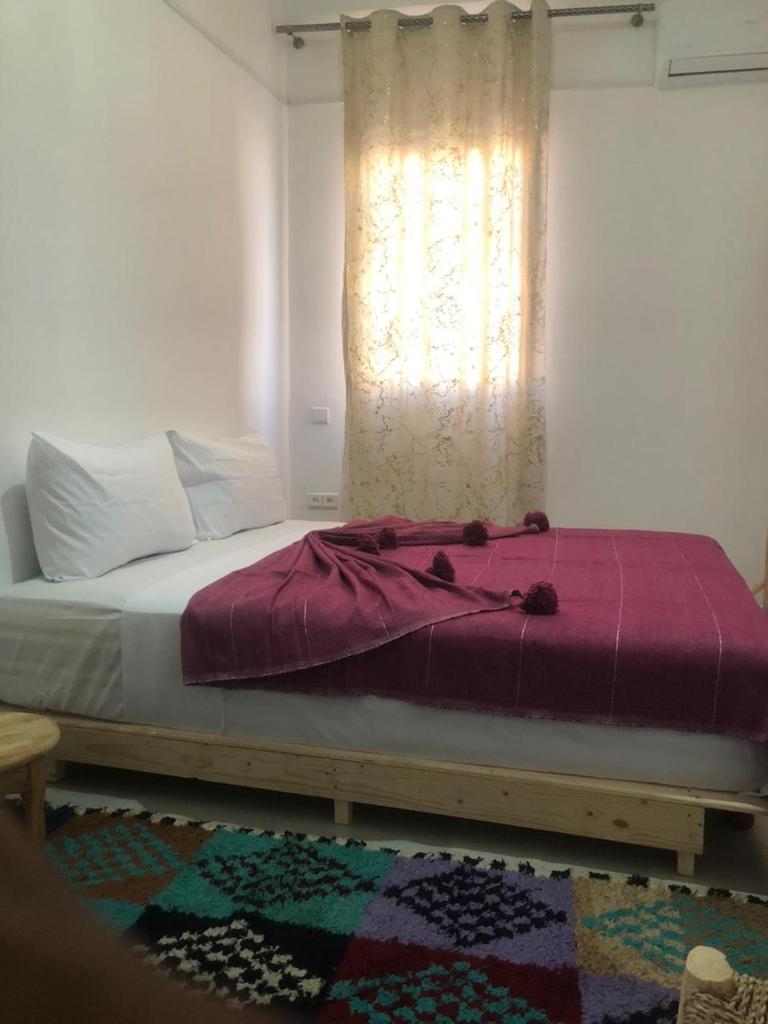 - un lit dans une chambre avec fenêtre dans l'établissement Riad Nomad House Marrakech, à Marrakech