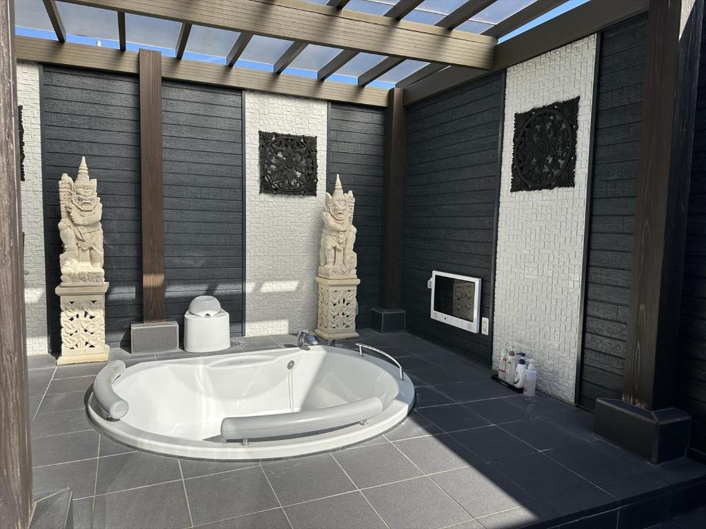 Cette chambre dispose d'une grande baignoire. dans l'établissement ホテル雅ロワイヤル, à Shimo-shirōzu