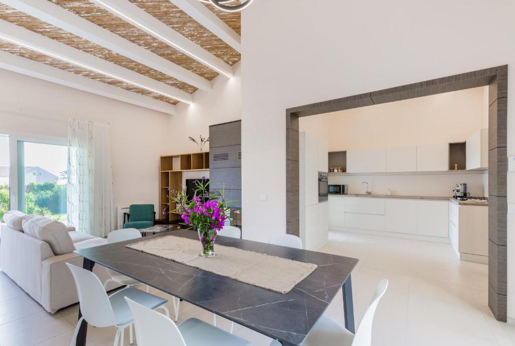 une salle à manger et un salon avec une table et des chaises dans l'établissement Dione Villa Mare di Ponente, à Donnalucata