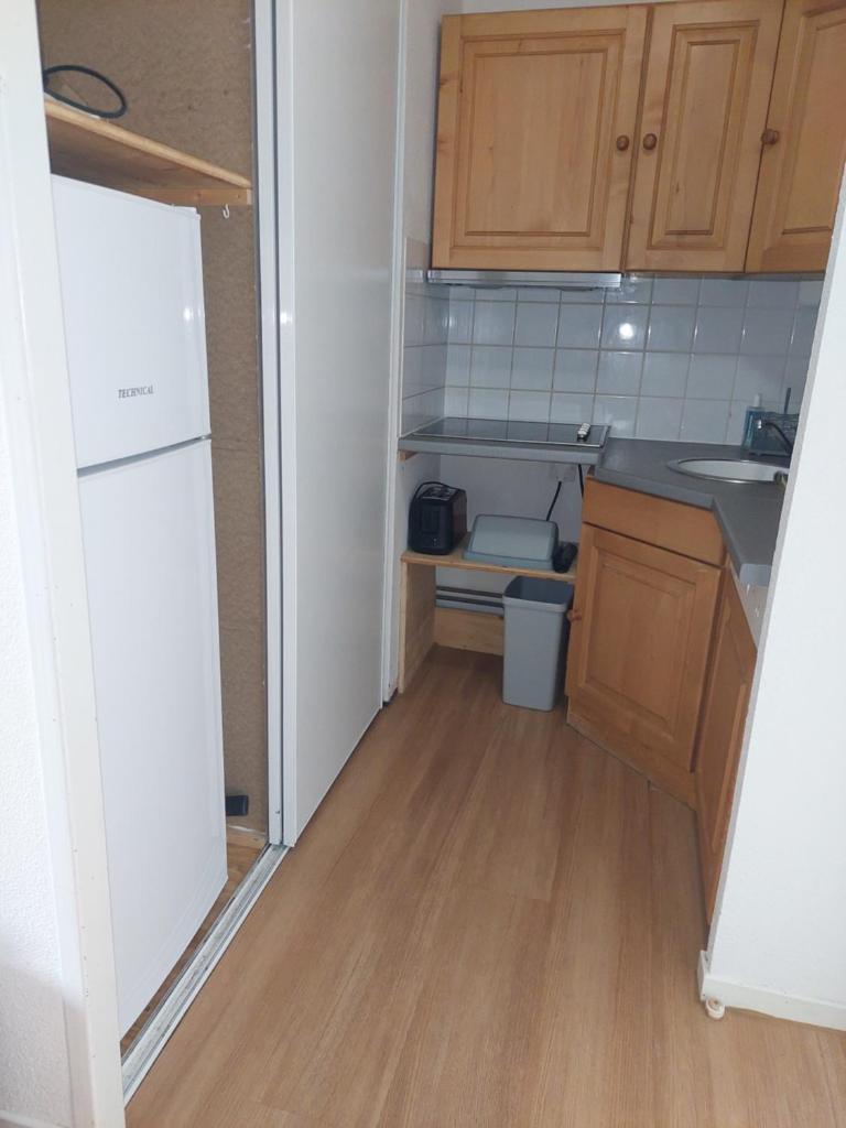 une petite cuisine avec un évier et un réfrigérateur dans l'établissement Super Besse 5/6 pers. Vue sur les monts du cantal, à Besse-et-Saint-Anastaise