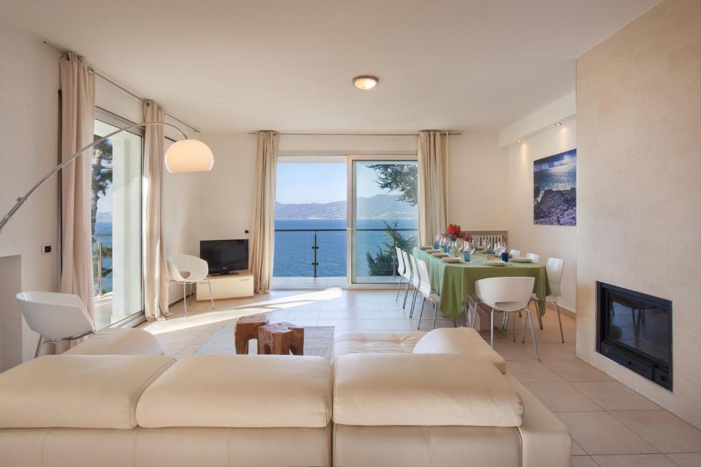 un salon avec un canapé et une table avec vue dans l'établissement Villa Vista Lago With Pool, à Torri del Benaco