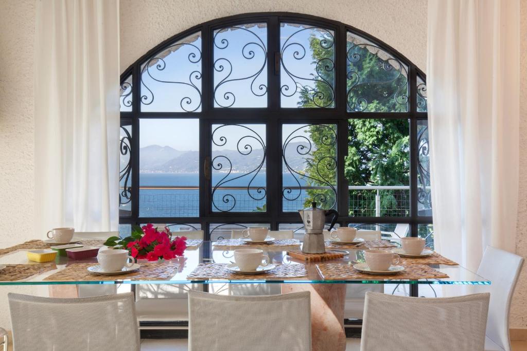 une salle à manger avec une table et une grande fenêtre dans l'établissement Villa Vista Lago With Pool, à Torri del Benaco