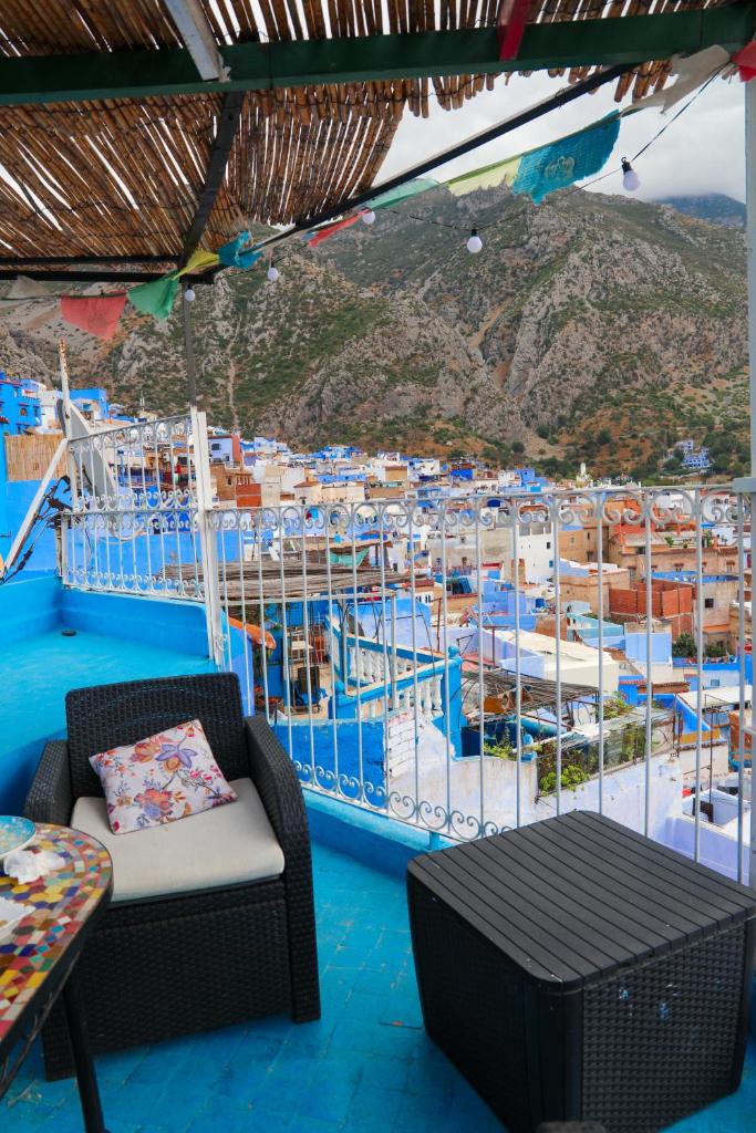 une chambre avec une chaise, une table et un bateau dans l'établissement Dar Sababa, à Chefchaouen