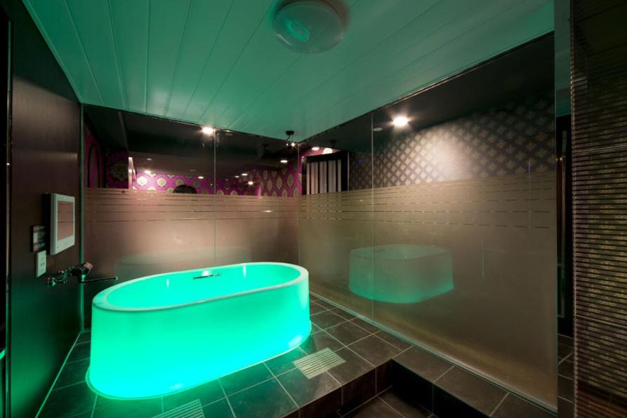 La salle de bains est pourvue d'une baignoire avec une lumière bleue. dans l'établissement HOTEL FIVE -Adult Only-, à Osaka