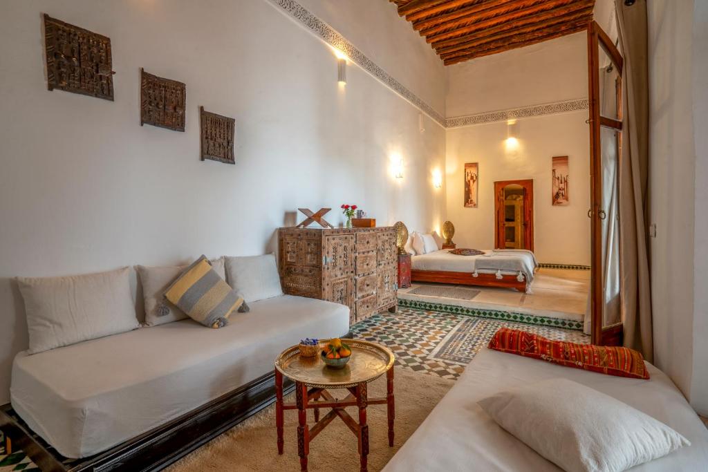 un salon avec un canapé et un lit dans l'établissement Riad Nora, à Marrakech
