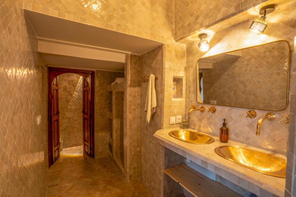 une salle de bain avec deux lavabos et un miroir dans l'établissement Riad Nora, à Marrakech