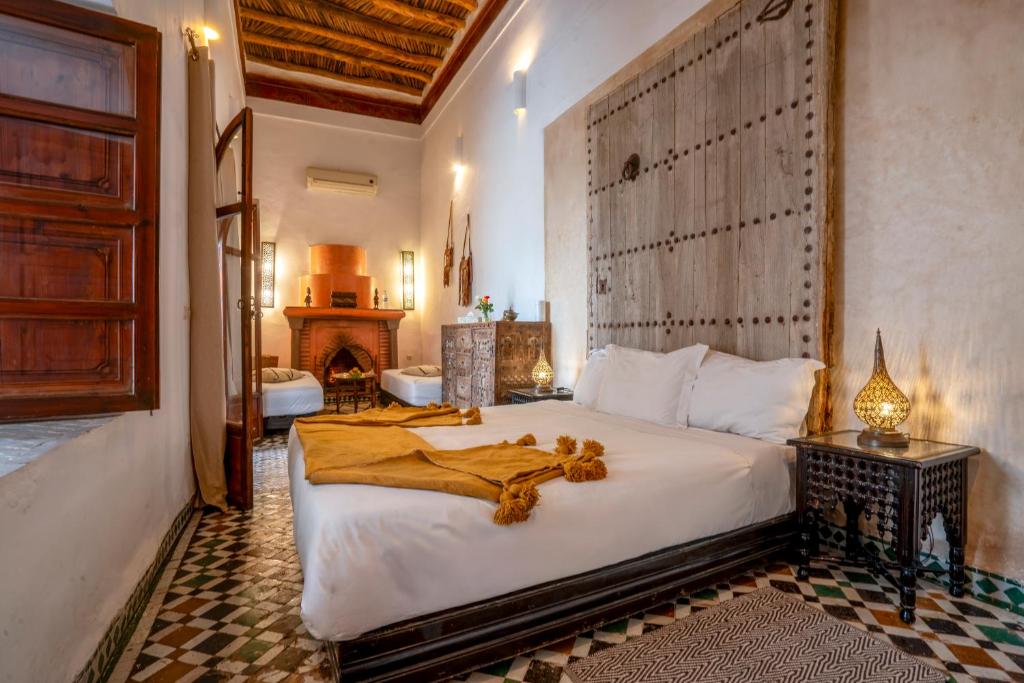 une chambre avec un grand lit avec une couverture dessus dans l'établissement Riad Nora, à Marrakech