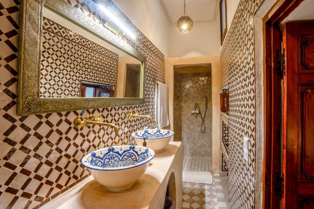 une salle de bain avec deux lavabos et un miroir dans l'établissement Riad Nora, à Marrakech 32 autres photos