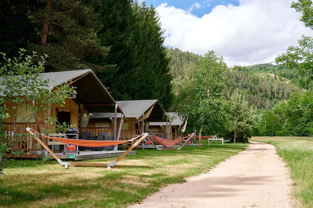 une maison avec un hamac en face de celle-ci dans l'établissement Glamping Haure-Loire, à Sainte-Sigolène