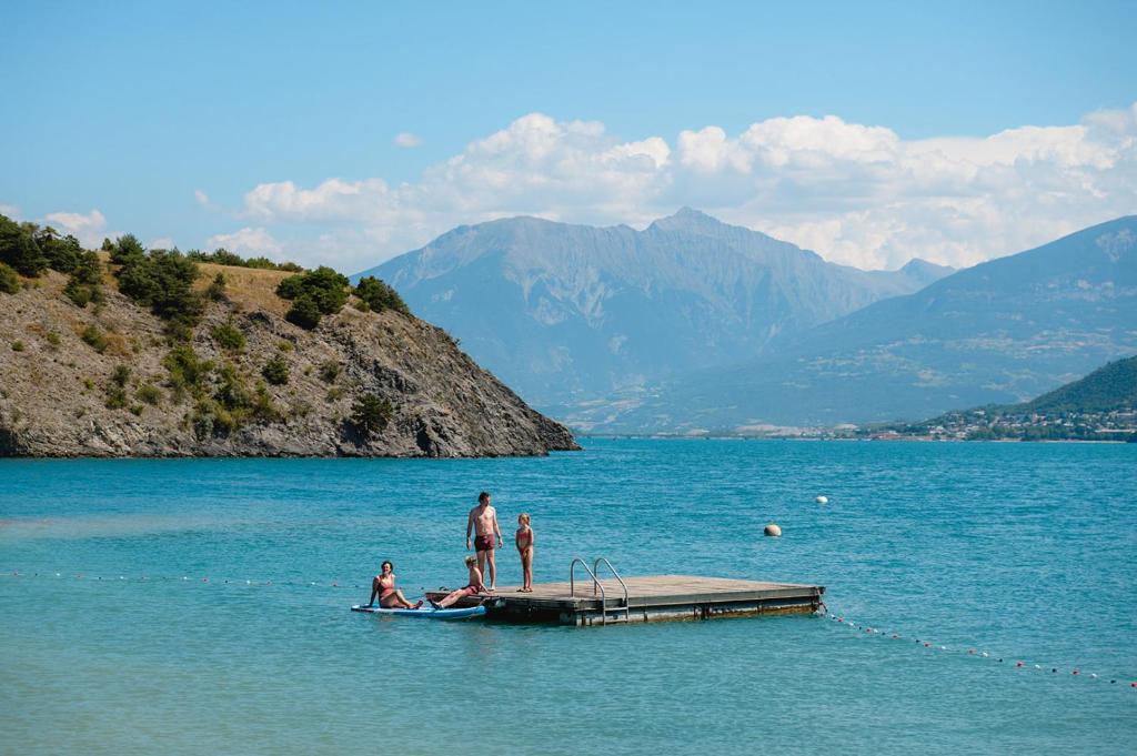 Un groupe de personnes sur un quai dans un lac dans l'établissement Glamping Hautes-Alpes, à Prunières